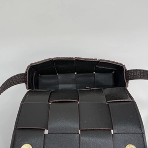 Detailed view of the wide leather weave and magnetic gold clasps on the brown bag
