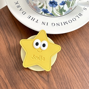 Détail du support de téléphone étoile jaune avec yeux 3D et texte Smile sur bois