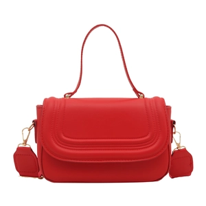 Red solid flap square bag with wavy embossing and wide shoulder strap in a front view