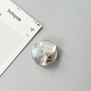 Close-up of a circular phone socket featuring faux jewels and a polished silver star charm