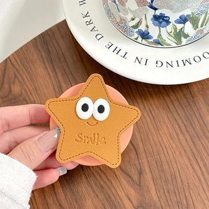 Détail du support téléphone étoile jaune avec de grands yeux blancs et motif Smile