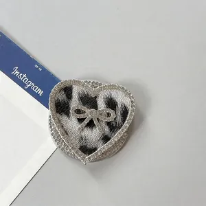 Detalle macro del soporte para móvil de corazón con leopardo y pedrería brillante