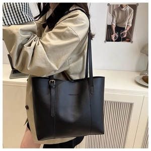 Close-up of black matte leather tote bag with FASHION & BAGS text and adjustable strap