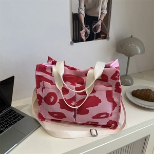 Sac fourre-tout à imprimé vache rose et rouge avec bandoulière sur un bureau élégant