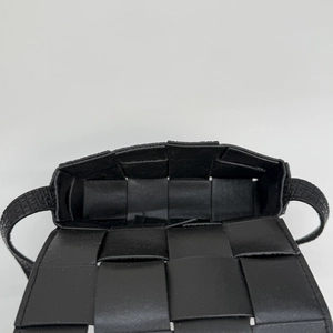 Detail of black woven leather handbag interior with wide strap and matte texture