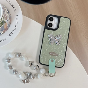 Close-up of light green pleated phone case with rhinestone butterfly and beaded charm
