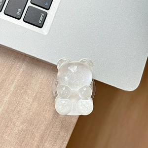 Detail shot of a glittery white bear phone grip on a laptop with soft lighting