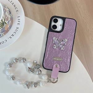 Detailed shot of purple pleated leather phone case with rhinestone butterfly and beaded strap