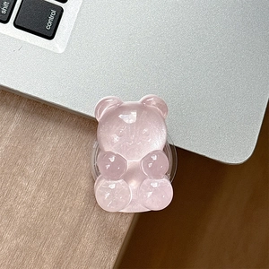 Pink glitter bear phone grip on a laptop keyboard showing aesthetic accessory detail
