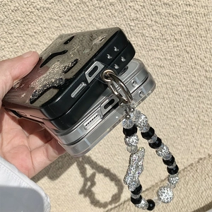 Detail of folding phone case with sparkling glitter stars and beaded wrist strap charm