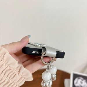 Detail of black leather iPhone case featuring silver glitter strap and beaded wristlet chain