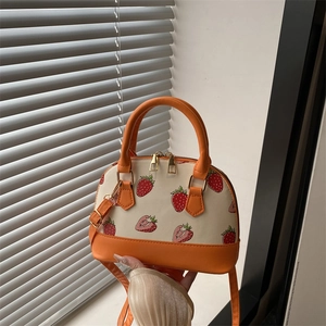 Fashionable strawberry print shell tote bag in orange and cream with crossbody strap