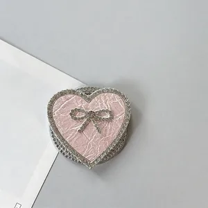 Primer plano detallado del soporte móvil de corazón rosa con lazo de diamantes