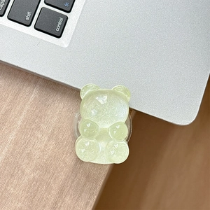 Detail of light green bear phone grip with glitter and crystal texture on laptop