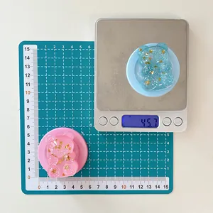 Detailed view of glitter bear phone stands showing dimensions and weight on a scale