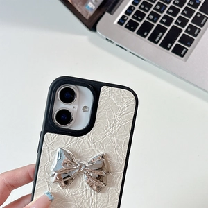 Close-up of cream leather phone case with a 3D silver bow and wrinkled texture for iPhone