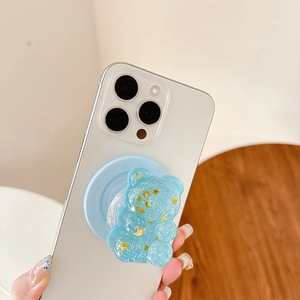 Light blue glitter bear phone stand with gold stars on white smartphone