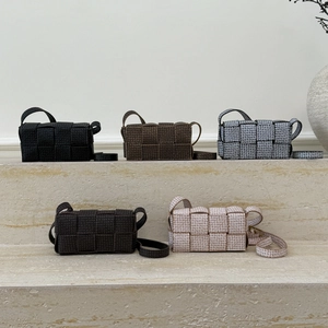 Chic woven crossbody bags set in five colors with intricate interlaced texture on stone steps