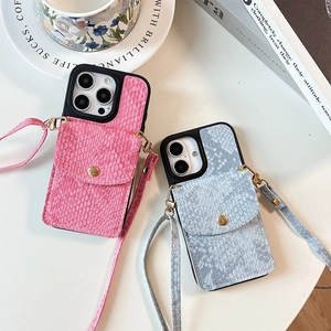 Close-up of snake skin textured iPhone cases with card slots and golden snap buttons
