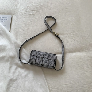 Mini woven crossbody bag with black and white geometric pattern on cream fabric