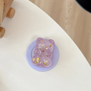Detailed macro view of purple glitter bear phone grip with golden star sequins