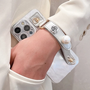 Silver mirror phone case with pearl wrist strap and metal camellia charm on white suit