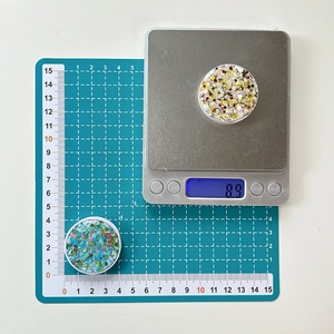 Detail of round glitter phone grip being measured on scale showing weight and 4cm diameter