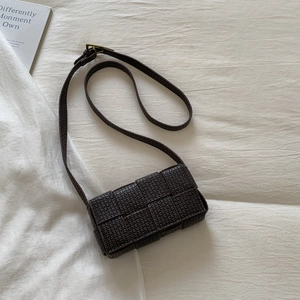 Mini woven crossbody bag in dark brown faux leather featuring a grid pattern and slim strap