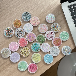 24-color glitter sequins set with stars and hearts in round boxes on a desk