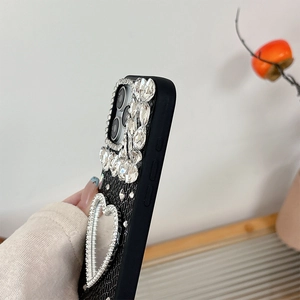 Macro shot of iPhone leather case with luxury crystals and heart-shaped vanity mirror