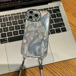 Close-up of holographic silver iPhone case with rhinestone bow and crossbody strap