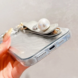 Detail shot of pearl wrist strap and rhinestone stand on iPhone protective case