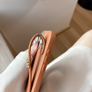 Macro side view of iPhone case featuring litchi leather texture and golden metal buckle