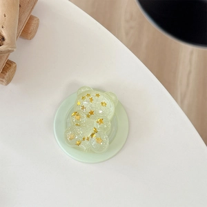Detail of cute green glitter bear phone socket with sparkling gold star sequins