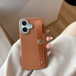 Macro shot of brown litchi leather texture phone case with metal rose wrist strap