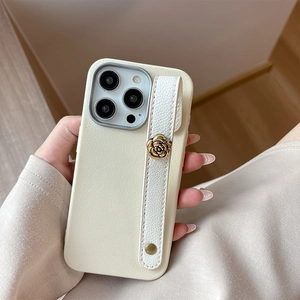 Detail of lychee pattern cream phone case with metal rose hand strap and gold studs