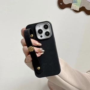 Detail of black litchi leather iPhone case with gold camellia wrist strap handle