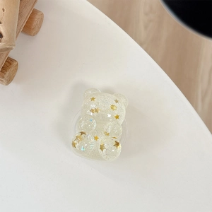 Close-up of bear-shaped phone grip with gold star sequins and silver glitter detail