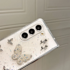 Detail of glitter phone case featuring pearl butterfly and metal rose floral charms