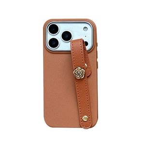 Brown litchi leather phone case with gold camellia wrist strap for iPhone 16 Pro Max
