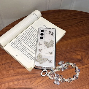 Z Flip case with glitter butterfly design and pearl beaded phone wrist strap on book