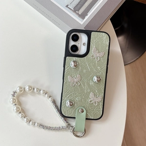 Détail d'une coque en cuir vert clair avec nœuds en cristal et bracelet en perles
