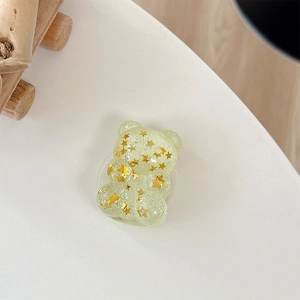 Close-up of bear-shaped phone grip with gold star sequins and sparkling resin details