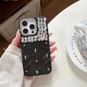 Détail d'une coque de luxe en cuir noir ornée de strass brillants et de clous argentés