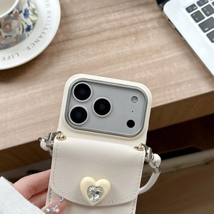 Vue macro d'une coque en cuir blanc cassé avec portefeuille cœur en strass et cordon blanc