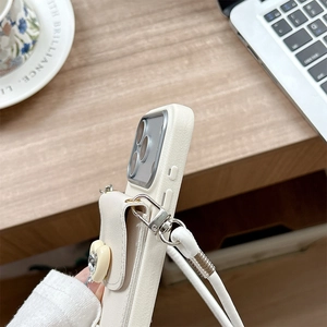 Détail de la coque iPhone en cuir crème avec mini portefeuille cœur et bandoulière