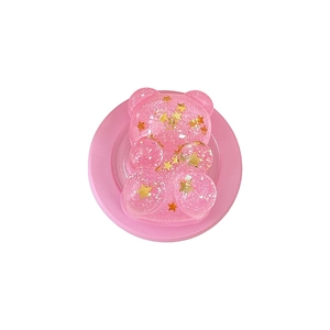 Pink glitter bear phone socket stand with gold star sequins on a white background