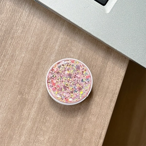 Macro shot of circular pink glitter phone socket with sparkling sequins on laptop background