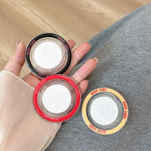 Detailed view of colorful Good Luck magnetic phone grip bases held in hand for scale