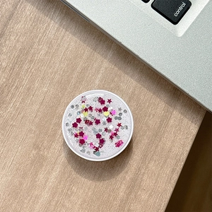 Detail view of round folding phone stand with sparkling purple glitter and sequins